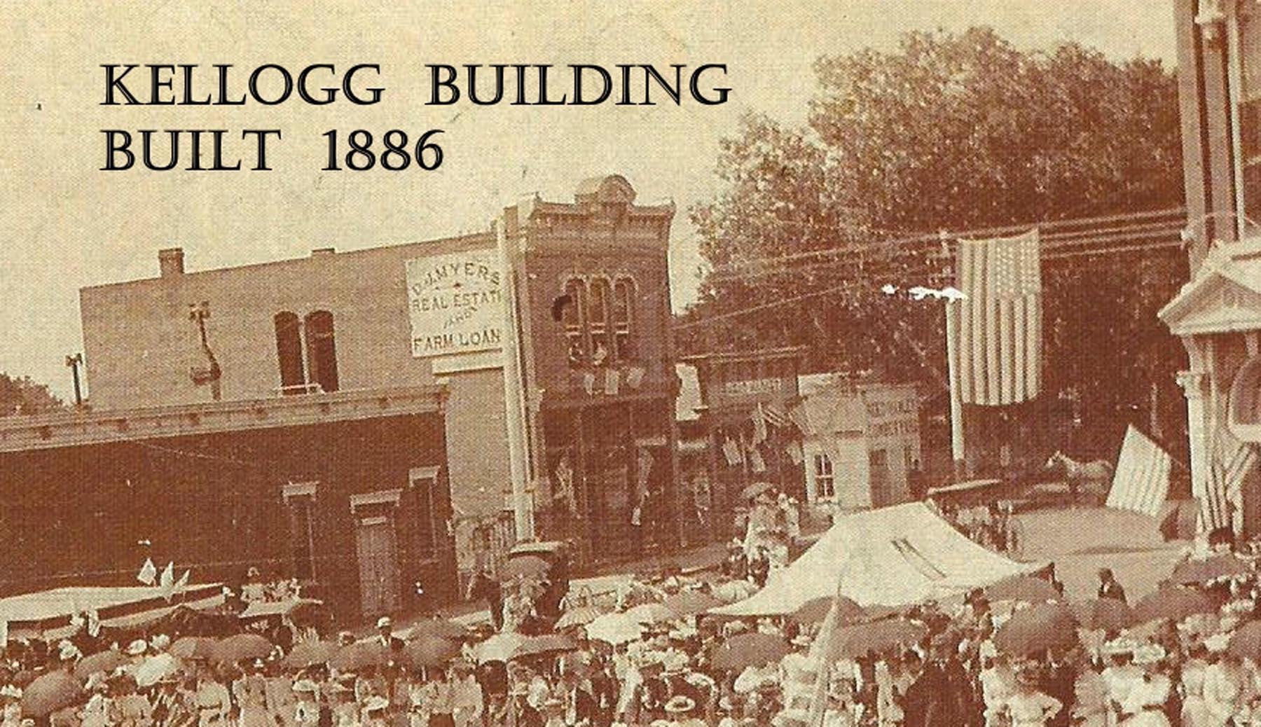 kellogg building shown in early 1900s parade - labeled- close-up