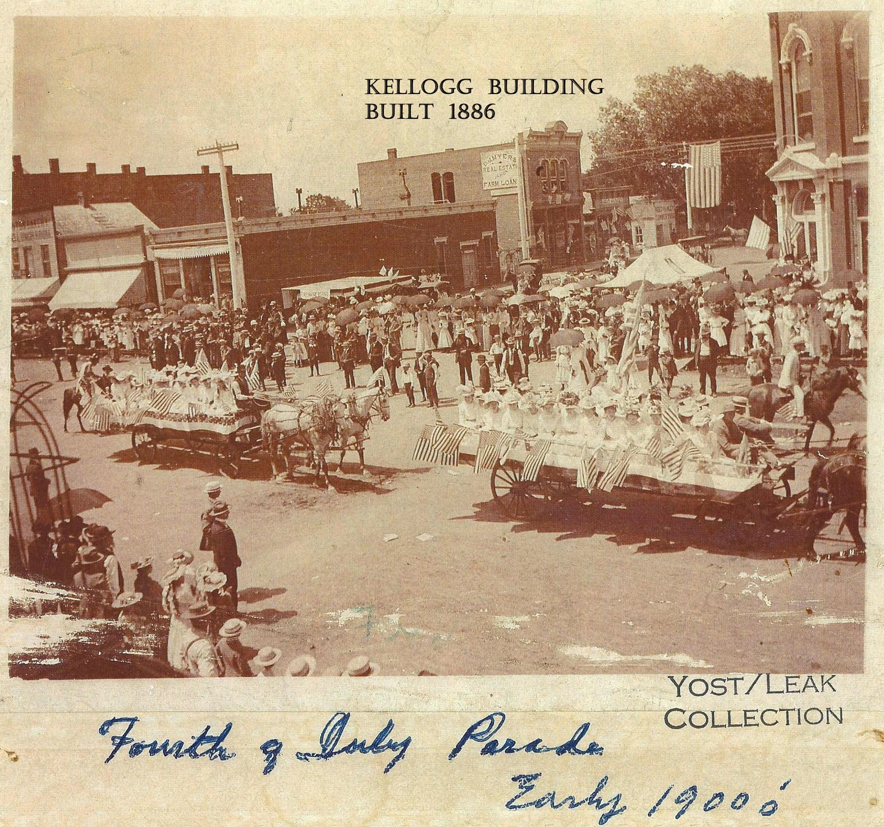 kellogg building shown in early 1900s parade - labeled